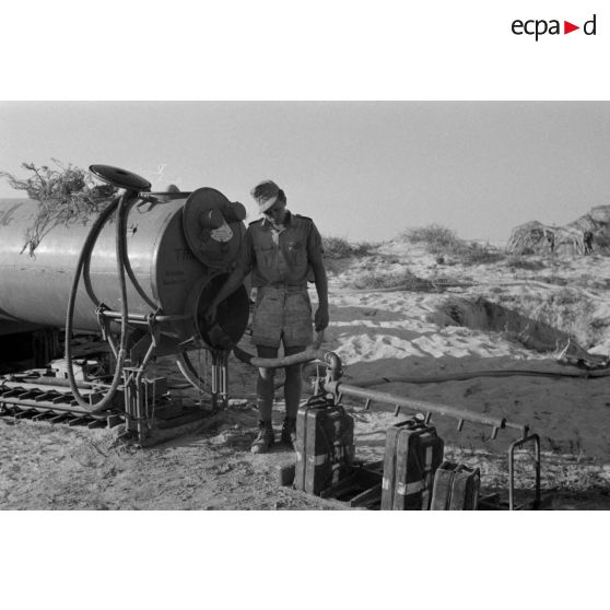 Des soldats remplissent des jerrycans d'eau potable.