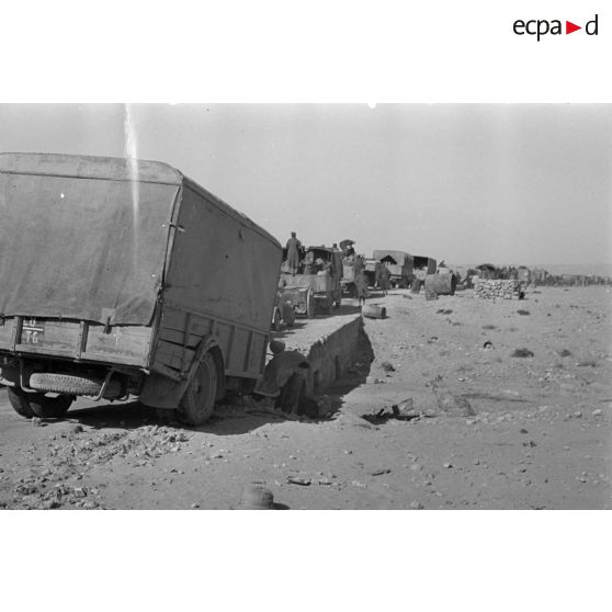 Passage d'un pont par une colonne de véhicules allemands et italiens, un camion accidenté a glissé hors du pont.