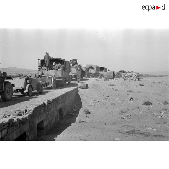 Passage d'un pont par une colonne de véhicules allemands et italiens, un camion accidenté a glissé hors du pont.