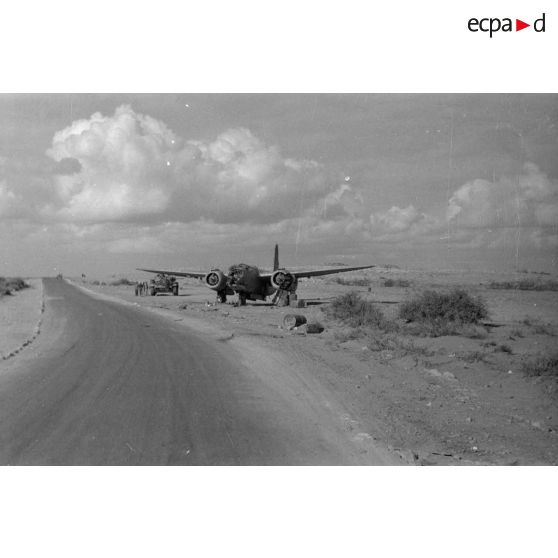 La carcasse d'un avion britannique Douglas Boston et en arrière plan un char Panzer III (Pz-III).