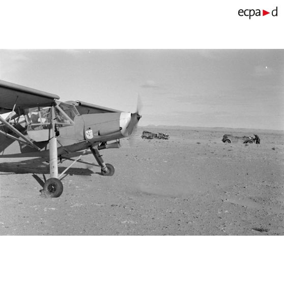 Un avion Fieseler Storch posé près de la colonne; on reconnaît le scorpion du Sonderkommando Dora.