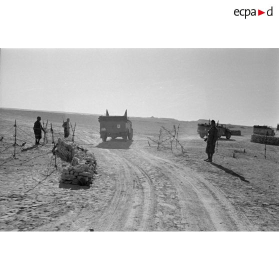 La colonne de véhicules dépasse un point de contrôle occupés par les troupes italiennes sur une piste.