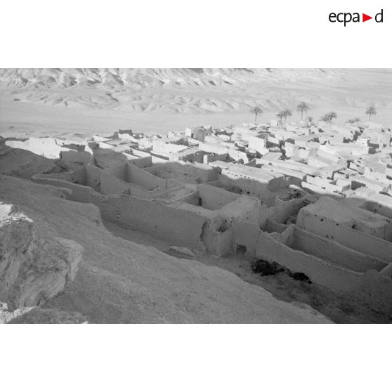 Un groupe d'officiers et de soldats observent la vallée et le village depuis une colline.