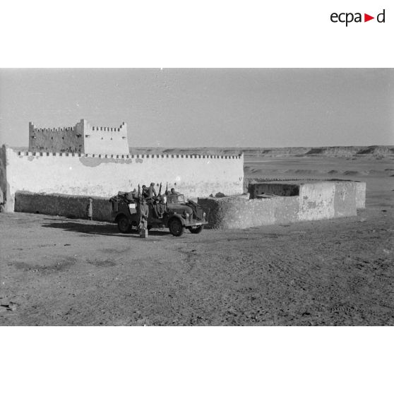 Deux camions dont un Steyer 1500 du Sonderkommando Dora et un Kfz-17 de transmissions sont garés dans le village près d'un fortin.