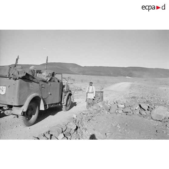 Une voiture Steyr 1500 passe près d'une jeune sentinelle appartenant aux troupes coloniales italiennes.