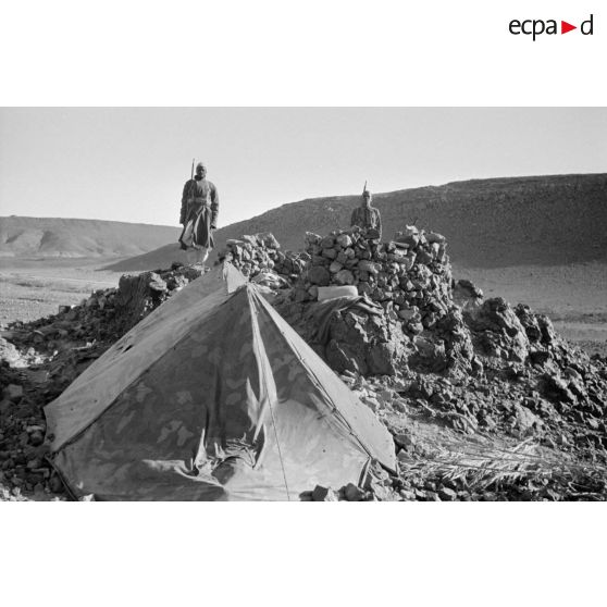 Deux soldats des troupes coloniales italiennes montent la garde près d'une alvéole et d'une tente.