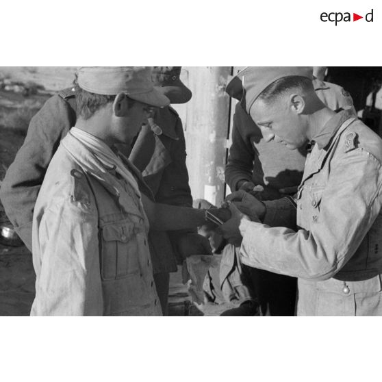 Un Oberleutnant, aidé par un Oberfeldwebel, soigne plusieurs blessés légers.