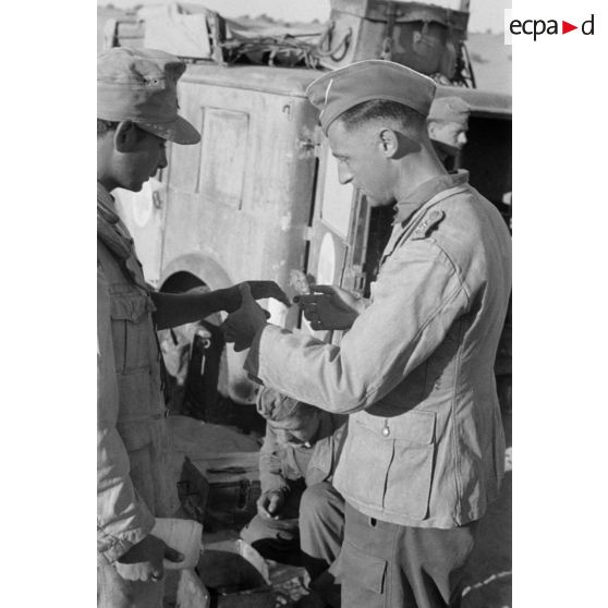 Un Oberleutnant, aidé par un Oberfeldwebel, soigne plusieurs blessés légers.