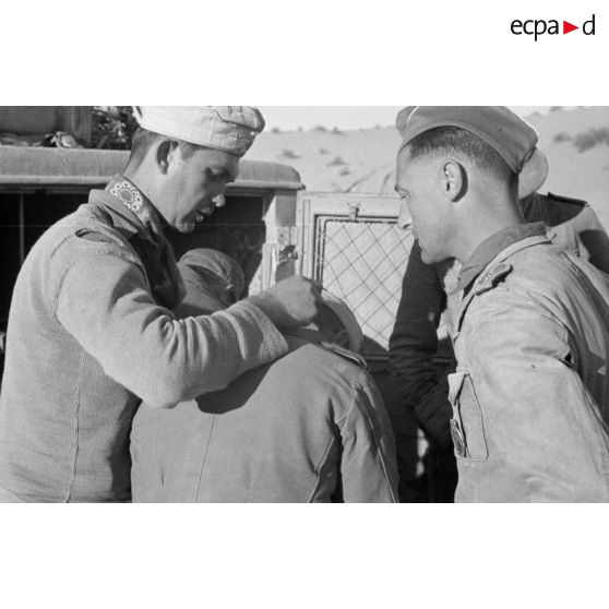 Un Oberleutnant, aidé par un Oberfeldwebel, soigne plusieurs blessés légers.