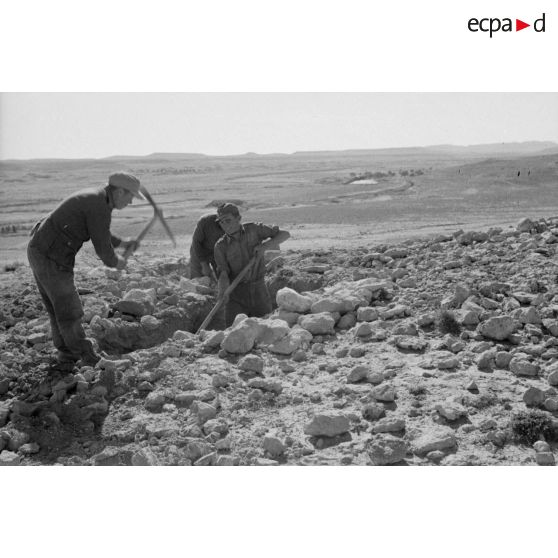 Des fantassins creusent des tranchées à flanc de colline.