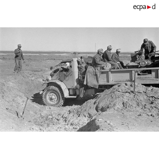 Le camion Ford 3T équipé d'un canon de 2 cm FlaK 38 quitte sa position de tir et regagne la piste.