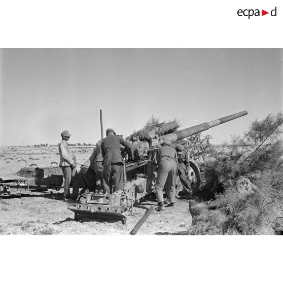 Les servants d'un canon de 10 cm K-18 en pleine action autour de la prièce d'artillerie.