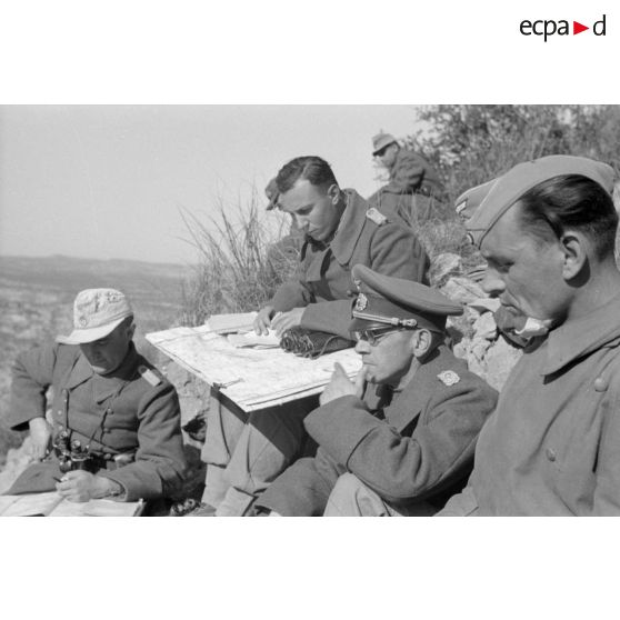 Un groupe d'officiers allemands de la 21-Pz.Div. est réuni au sommet d'une colline.