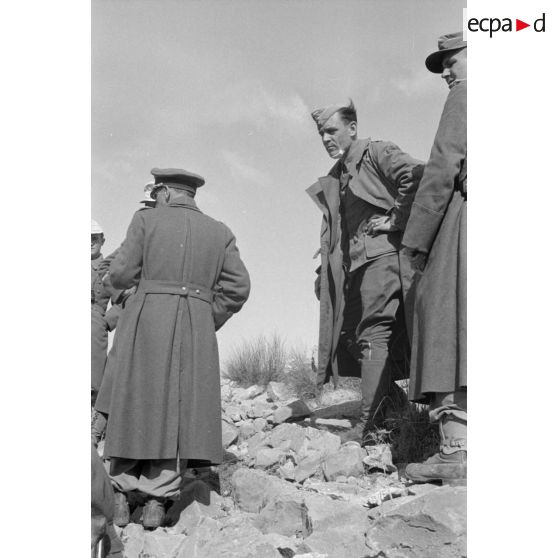 Un groupe d'officiers allemands de la 21-Pz.Div. est réuni au sommet d'une colline.