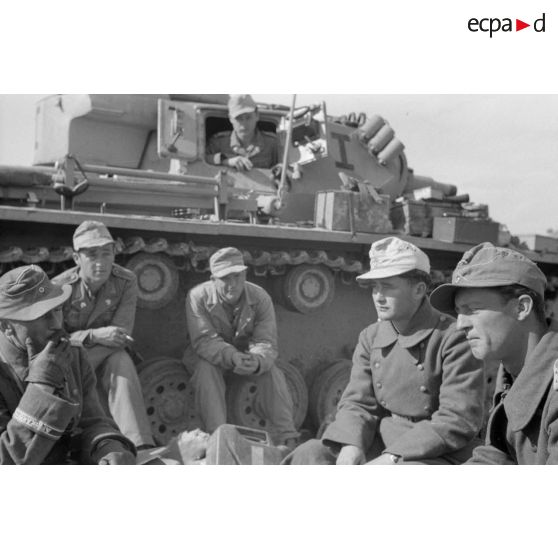 Un capitaine (Hauptmann) appartenant au I-Pz.Rgt-5 (Panzer Regiment 5) parle avec ses hommes près d'un char Panzer III (Pz-III Ausf-N).