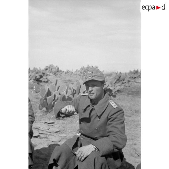 Un capitaine (Hauptmann) appartenant au I-Pz.Rgt-5 (Panzer Regiment 5) parle avec ses hommes près d'un char Panzer III (Pz-III Ausf-N).