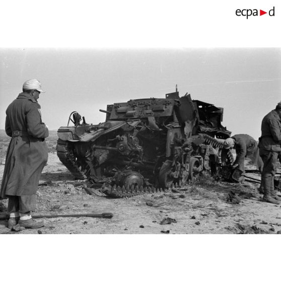 Des soldats allemands inspectent l'épave d'un char américain M3 Stuart détruit.