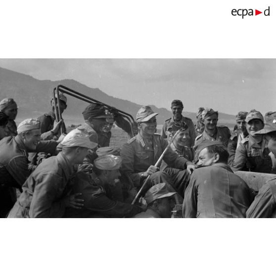 Un Hauptmann assis dans une jeep est entouré de ses hommes. Ils appartiennent certainement au Panzer Regiment 8.