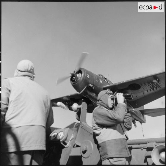 Avion bombardier Grumman TBM-3S Avenger passant au dessus du personnel de piste du porte-avions l'Arromanches.