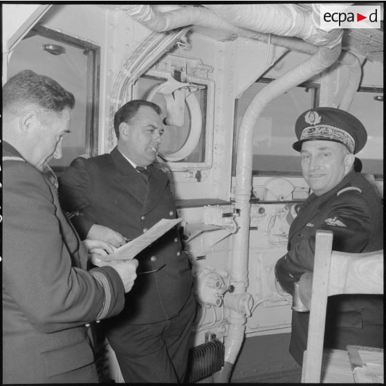 Discussion entre trois officiers supérieurs lors d'un exercice à bord du porte-avions l'Arromanches en Méditerranée.