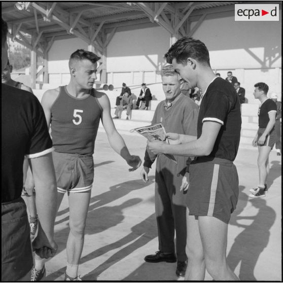 Echange de fanions entre les deux capitaines d'équipe avant la finale de basket-ball de la Xe région militaire.