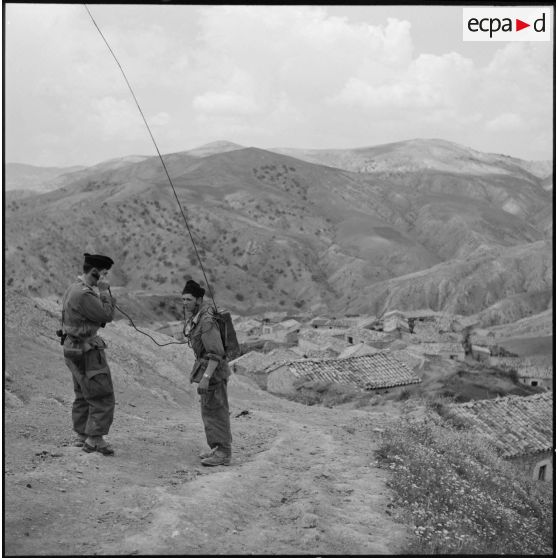 Communication radio sur un poste SCR-300 par des soldats du 72e GA (groupe d'artillerie) à l'entrée du village de Bou Arroua.