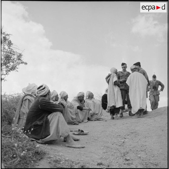 Discussion entre des soldats du 72e GA (Groupe d'artillerie) et des hommes du village Bou Aoua.