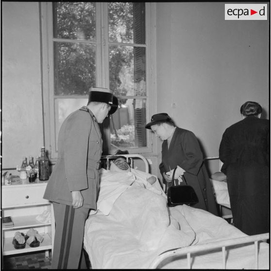 Visite de Mme Lacoste, femme de Robert Lacoste (gouverneur général d'Algérie) aux blessés de l'hôpital Maillot d'Alger.