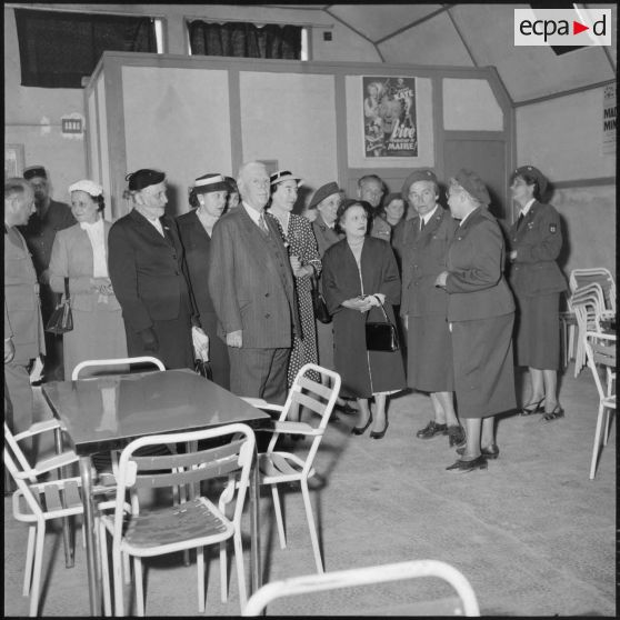 Visite du foyer de l'hôpital Maillot d'Alger par Mme Lacoste, femme de Robert Lacoste (gouverneur général d'Algérie) entourée d'autorités.