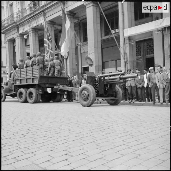 Défilé de l'artillerie avec un GMC 6x6, tractant un canon de 105mm dans les rues de Bône à l'occasion des commémorations du 8 mai.