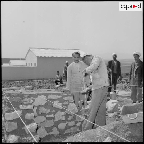 Construction d'un mur sur le chantier de nouvelles habitations à Randon (Besbes) par des ouvriers algériens.