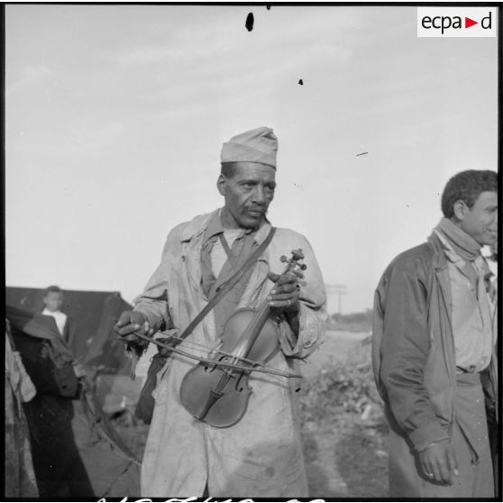 Musicien algérien jouant du violon près du chantier de nouvelles habitations à Bou Ahra.