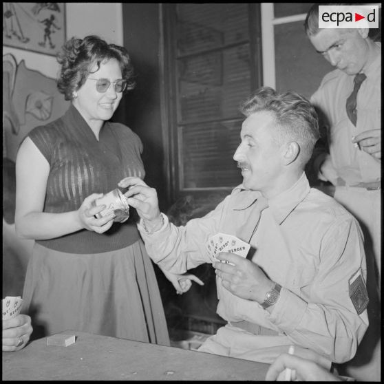 Demoiselle offrant une cigarette à un brigadier-chef du 117e régiment d'infanterie (RI) venant de débarquer à Alger.