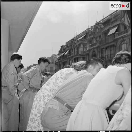 Des soldats du 117e régiment d'infanterie (RI) et des étudiantes sur un balcon