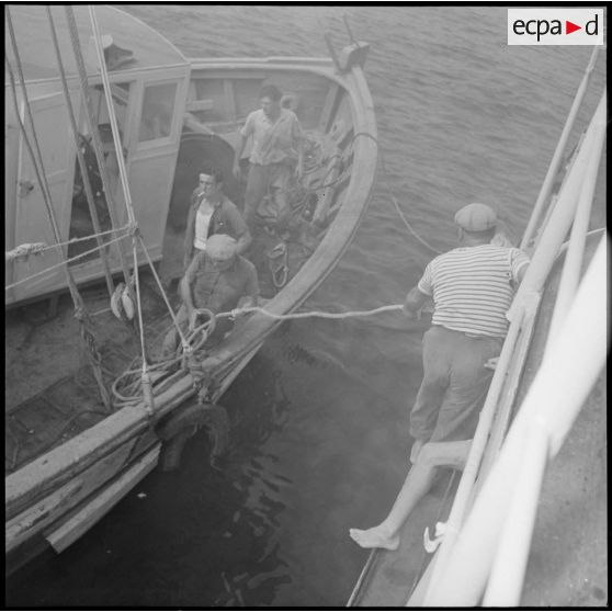 Un bateau de pêche abordant le patrouilleur côtier La Pique.