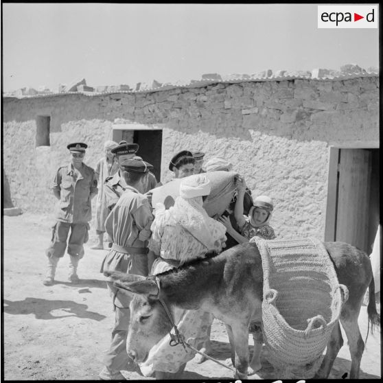 Des fusiliers-marins du 2e bataillon de la 1re demi-brigade de fusiliers-marins (DBFM) aidant un meunier.