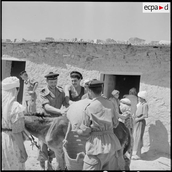 Des fusiliers-marins du 2e bataillon de la 1re demi-brigade de fusiliers-marins (DBFM) aidant un meunier.