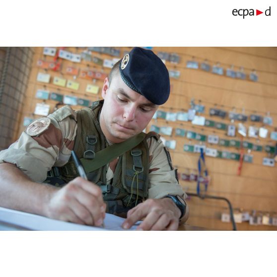 Le sergent-chef Benjamin, chef du poste de sécurité, enregistre les entrées et sorties du camp de Bamako, au Mali.