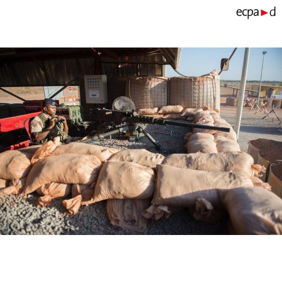 Un bigor du 3e régiment d'artillerie de marine (3e RAMa) sécurise l'entrée au moyen d'une mitrailleuse Browning M2 au poste de sécurité du camp de Bamako, au Mali.