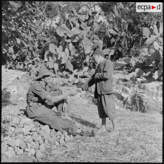 Un fusilier-marin du 1er bataillon de la 1re demi-brigade de fusiliers-marins (DBFM) offrant des bonbons à un enfant.