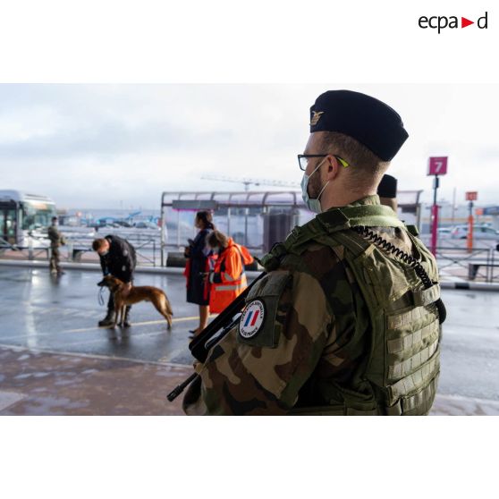 Un soldat sécurise une zone de colis suspect aux côtés d'agents aéroportuaires à Orly.