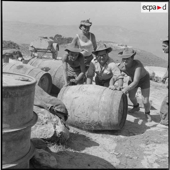 A l'intérieur du poste d'implantation, des marins font rouler un tonneau.