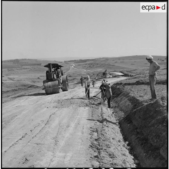 Des ouvriers algériens déblayent les abords de la piste en cours de construction par le 9e BG.