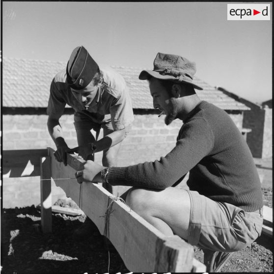 Deux soldats de la 3/131e régiment d'infanterie (RI) vérifient le niveau d'un repère d'implantation d'un nouveau baraquement.