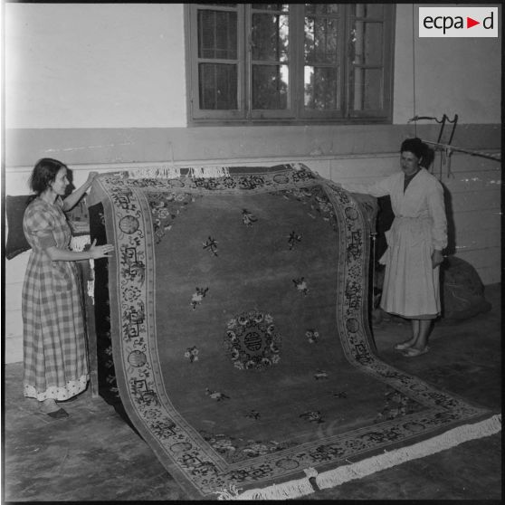 Présentation d'un tapis manufacturé à Tlemcen.