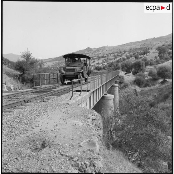 Un véhicule blindé patrouille sur des rails de chemin de fer.