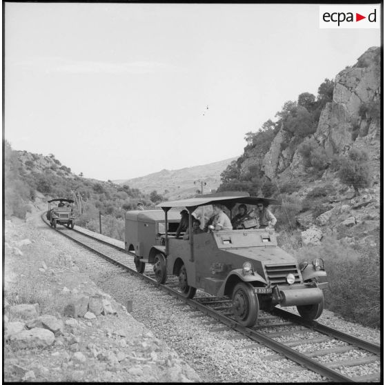 Deux véhicules blindés patrouillent sur des rails de chemin de fer.