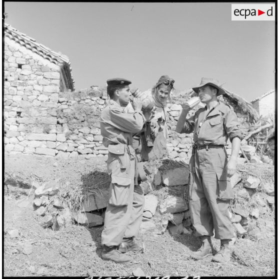 Une femme offre à boire à nos soldats.