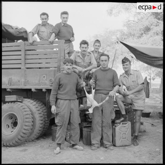 Portraits d'un groupe de rappelés du 10e régiment de dragons (RD) devant un camion militaire.