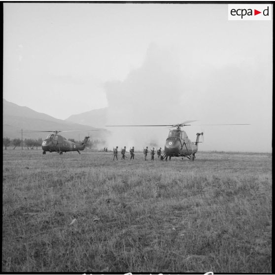 Les soldats du 2e régiment de parachutistes coloniaux (RPC) embarquent à bord d'un hélicoptère sur un terrain vague.